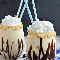 two glasses filled with whipped cream and chocolate