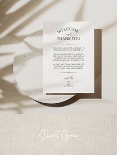 a white plate with a thank card on it next to a shadow of a palm tree