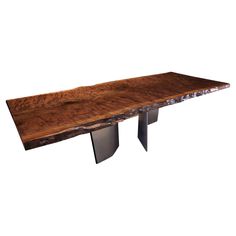 a wooden table with two metal legs and a slab of wood on the top that has been cut in half