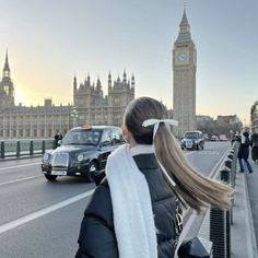 a woman standing on the side of a road near big ben