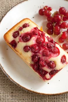 a piece of cake on a plate next to some grapes