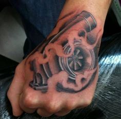 a man's hand with a tattoo on it that has an engine in the middle