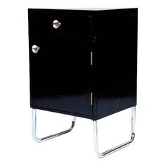 a black cabinet with two chrome handles on the front and bottom, against a white background