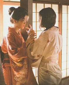 two women in kimonos looking at each other