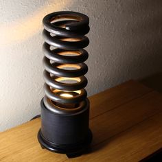 a wooden table with a lamp on top of it and a spiral design in the middle