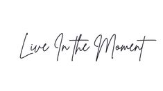 the words live in the moment written with black ink on a white background, against a plain backdrop