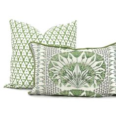 three pillows with green and white designs on them