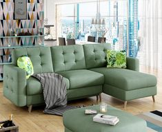 a living room with a green couch and ottoman