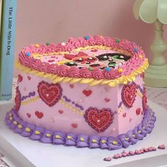 there is a pink cake with hearts on it