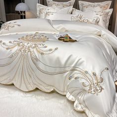 a bed with white sheets and gold trimmings