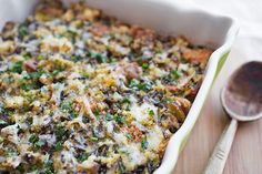 a casserole dish with mushrooms, cheese and parsley in it next to a spoon