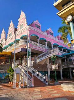 a pink building with many balconies on the top and stairs leading up to it