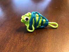 a small green and blue toy sitting on top of a wooden table