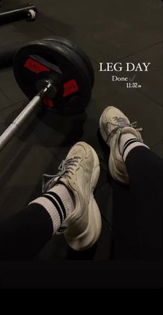 a pair of shoes and a barbell in front of a poster for leg day