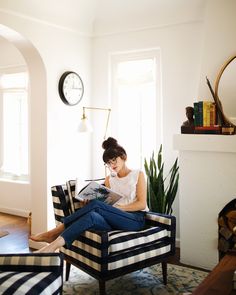 a woman sitting in a chair reading a book