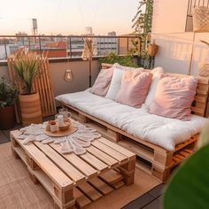 a wooden couch sitting on top of a patio next to a table and potted plants