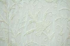 a white wallpaper with an intricate design on it's face and bottom corner