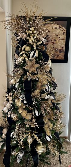 a christmas tree decorated with gold and black ornaments