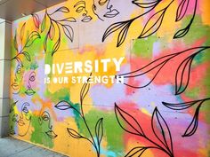 there is a mural on the side of a building that says, diversity is our strength