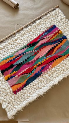 a close up of a piece of cloth on a table with yarn and scissors in the background