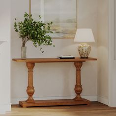 a wooden table with a plant on top and a lamp in the corner next to it