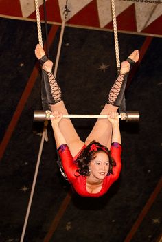 a woman hanging upside down on a rope