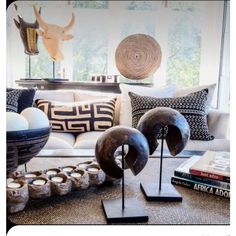 a living room filled with lots of furniture and decor on top of a floor next to a window