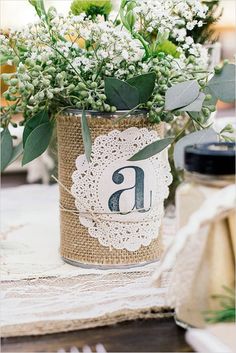 there is a vase with some flowers in it on the table next to utensils