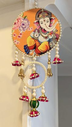 an image of a wall hanging decoration with beads and pearls on the bottom half of it