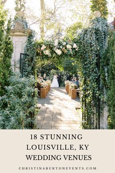 an outdoor wedding venue with greenery and flowers on the walkway, surrounded by trees