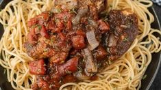 pasta with meat and tomato sauce on a black plate