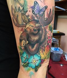 a moose with flowers and butterflies on his arm