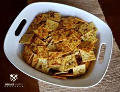 a white bowl filled with cheesy crackers on top of a table