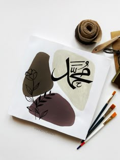 an open book with arabic writing on it next to crayons and other art supplies