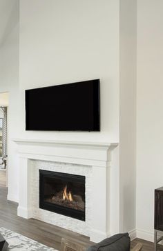 a living room with a fireplace and flat screen tv mounted on the wall above it