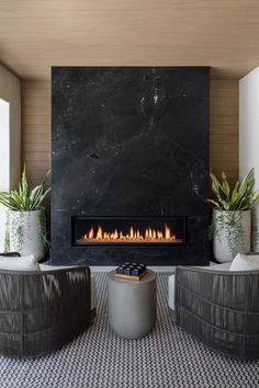 a living room with two chairs and a fire place in the middle of the room