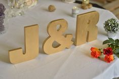 the letters j and r are made out of wood, sitting on a table with flowers