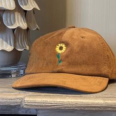 Introducing our stylish Embroidered Motif Corduroy Cap - Sunflower;  a must-have accessory for any fashion-conscious individual. Made from high-quality corduroy fabric, our cap offers a relaxed fit that is both comfortable and stylish. What makes this cap unique is the beautiful, embroidered sunflower motif on the front - perfect to add a touch of charm to any outfit.  We also offer additional embroidery on the back of the cap, which allows you to personalise the product to your liking. You can choose to have your name or initials embroidered, making the cap truly one-of-a-kind. Our Corduroy Caps are perfect for any occasion, whether it's a casual day out or a special event. They're easy to pair with any outfit, and the relaxed fit ensures that they're comfortable to wear all day long. CAP Sunflower Motif, Embroidered Corduroy, Embroidery Caps, Summer Stuff, Cotton Drawstring Bags, Personalized Embroidery