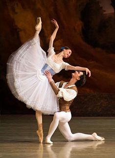 two ballerinas in white tutus are performing on stage