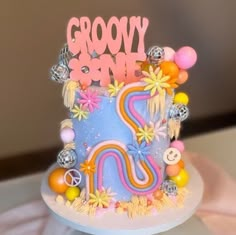 there is a colorful cake with the word grooy on it and many other decorations