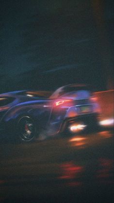 a blurry photo of two cars driving down the road at night with their headlights on