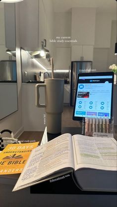 an open book sitting on top of a desk next to a computer