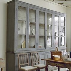 a dining room table with chairs and china cabinet