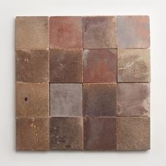 a brown and tan tile wall hanging on a white wall