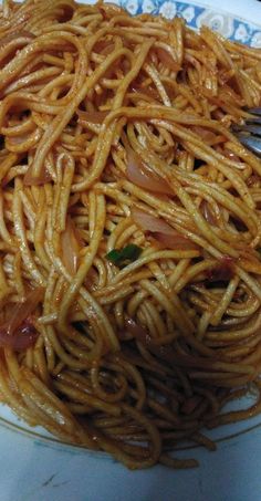 a plate full of noodles with sauce on it and a fork stuck in the bowl