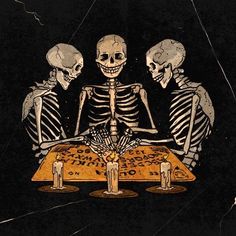 three skeletons sitting at a table with candles in front of them