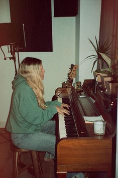 a woman sitting at a piano playing music