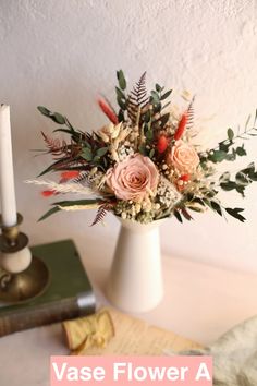 a vase filled with flowers sitting on top of a table next to a lit candle