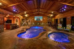 a large indoor swimming pool with blue lights