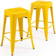 two yellow metal stools sitting next to each other on a white background with no one in the photo